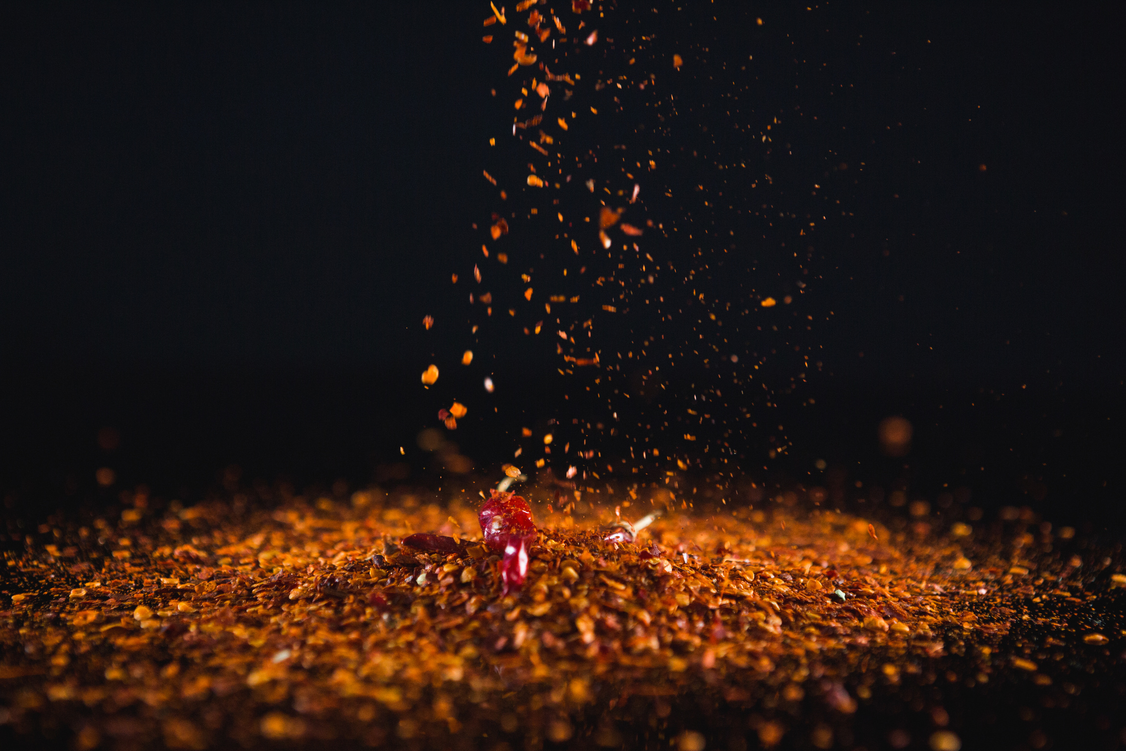 Red chilli flakes against black background